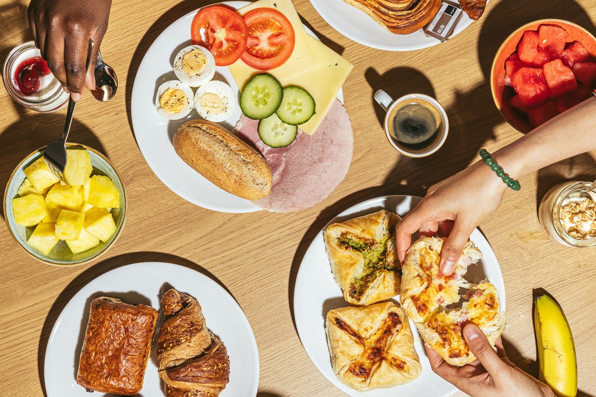 Breakfast plate with assorted pastries, eggs, cucumber slices and fruit at Point A Hotel Kings Cross